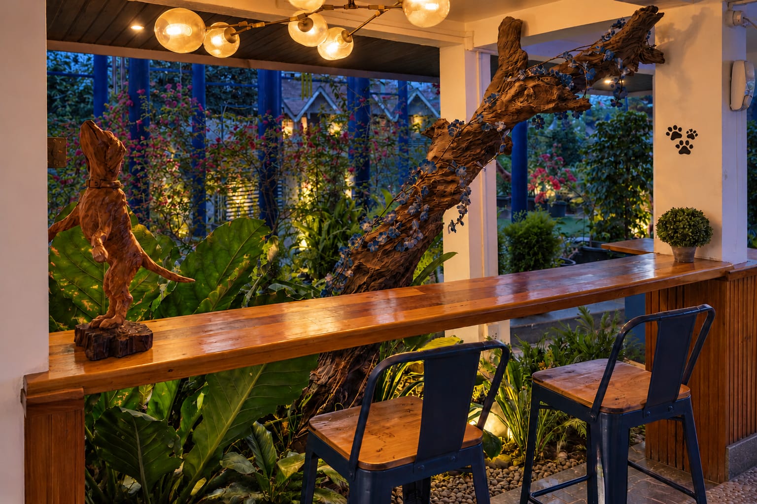 The wooden bar counter along the garden window, with blue stools and carved driftwood figures